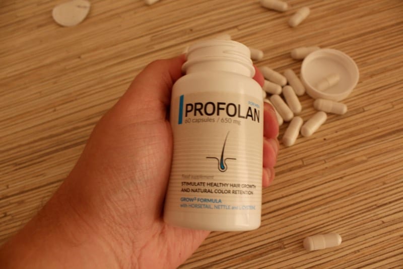Profolan 14 hand holds a bottle of pills.