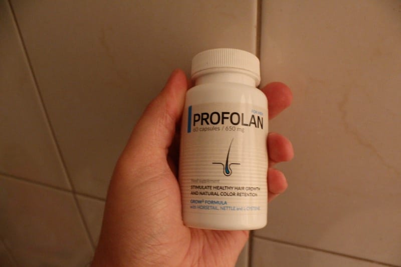 Profolan 16 hand holds a bottle of pills.