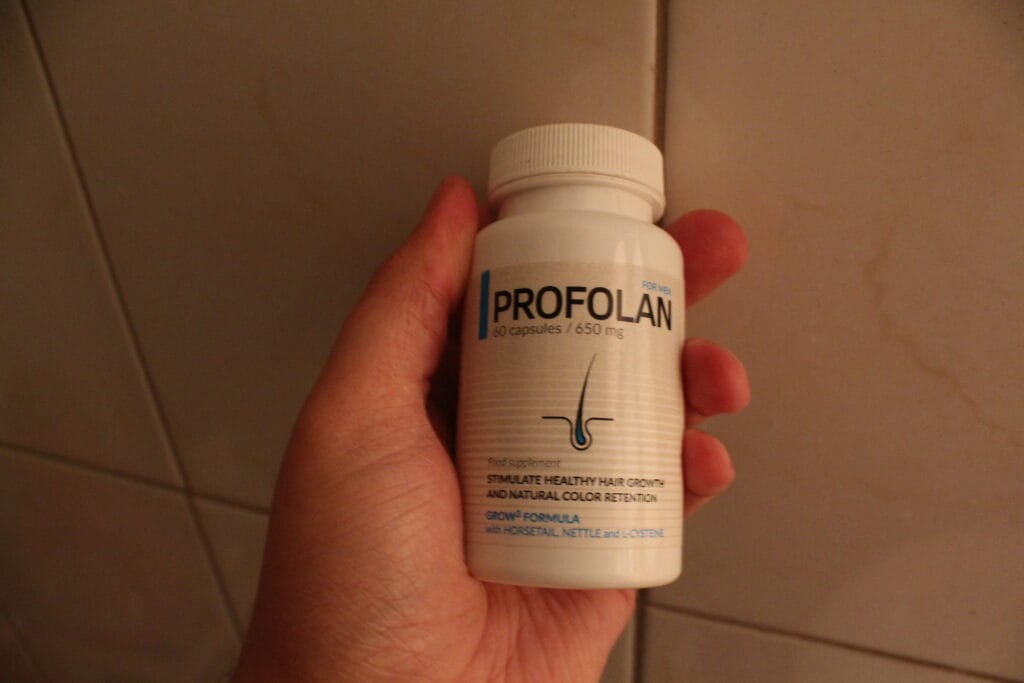 Profolan 15 hand holds a bottle of pills.