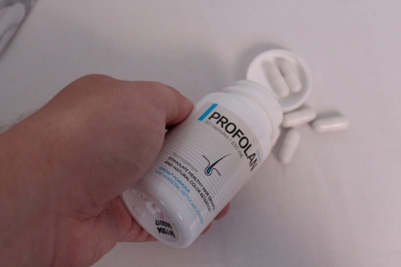 Profolan 3 hand holds a bottle of pills.