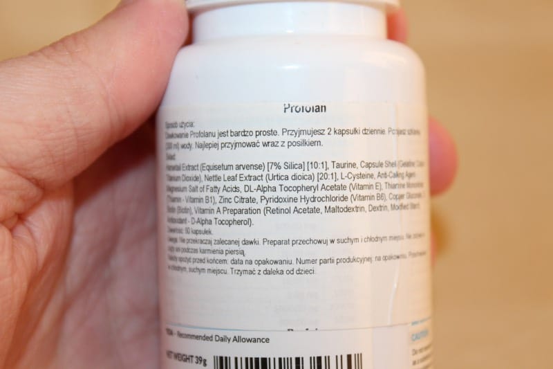 Profolan 9 hand holds a bottle of pills.