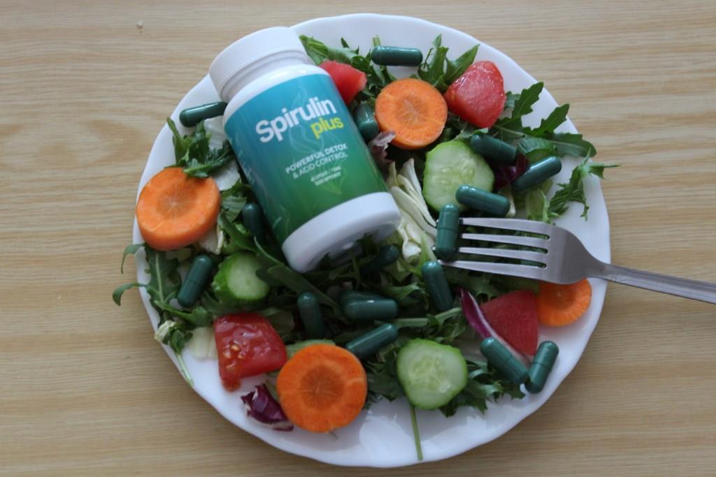 Spirulin Plus 9 medicine bottle on a plate of green salad